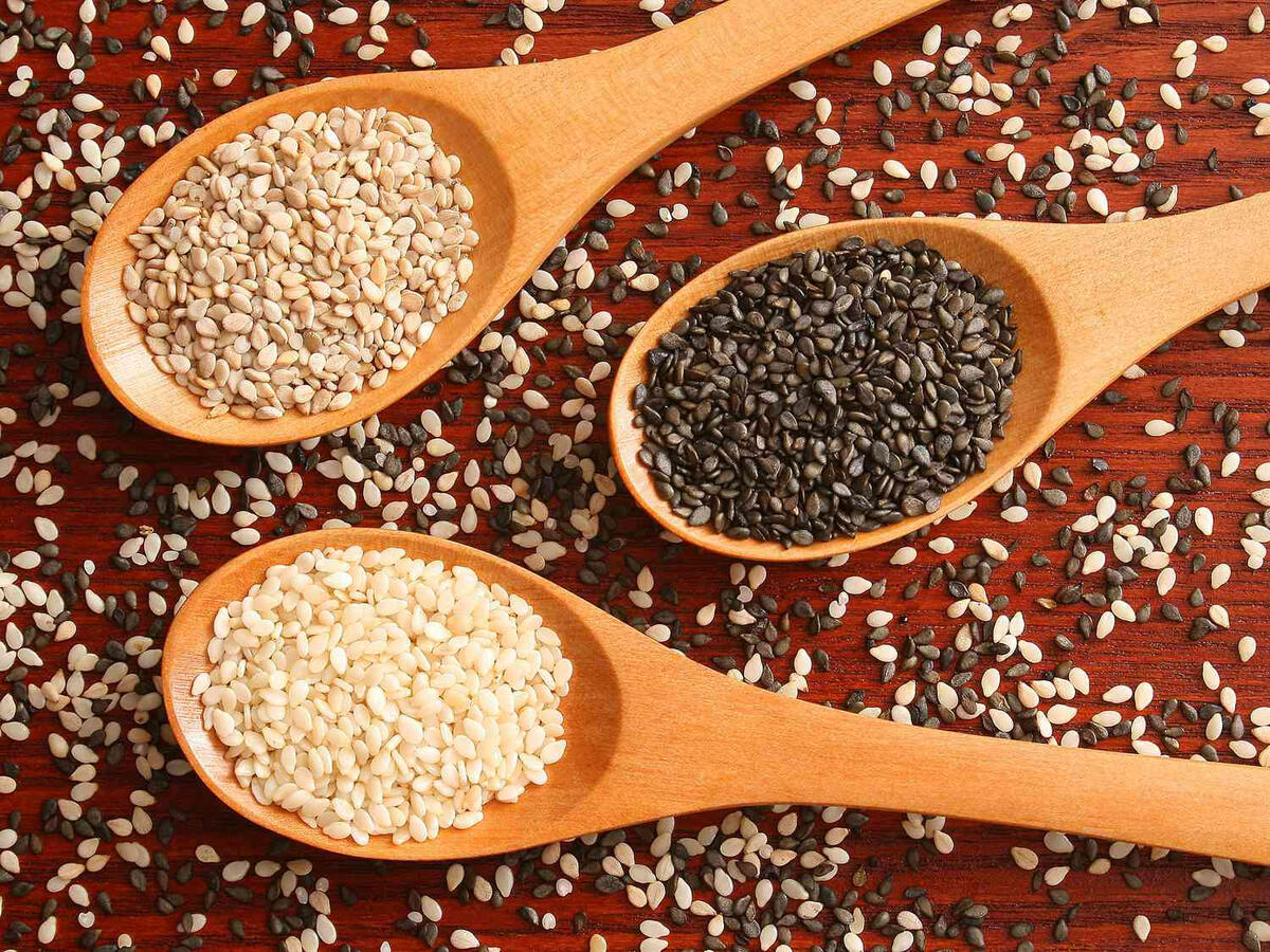 Ethiopian Sesame Seeds – White and Black Varieties Three wooden spoons filled with white and black Ethiopian sesame seeds, showcasing Afra Sourcing’s agricultural export products